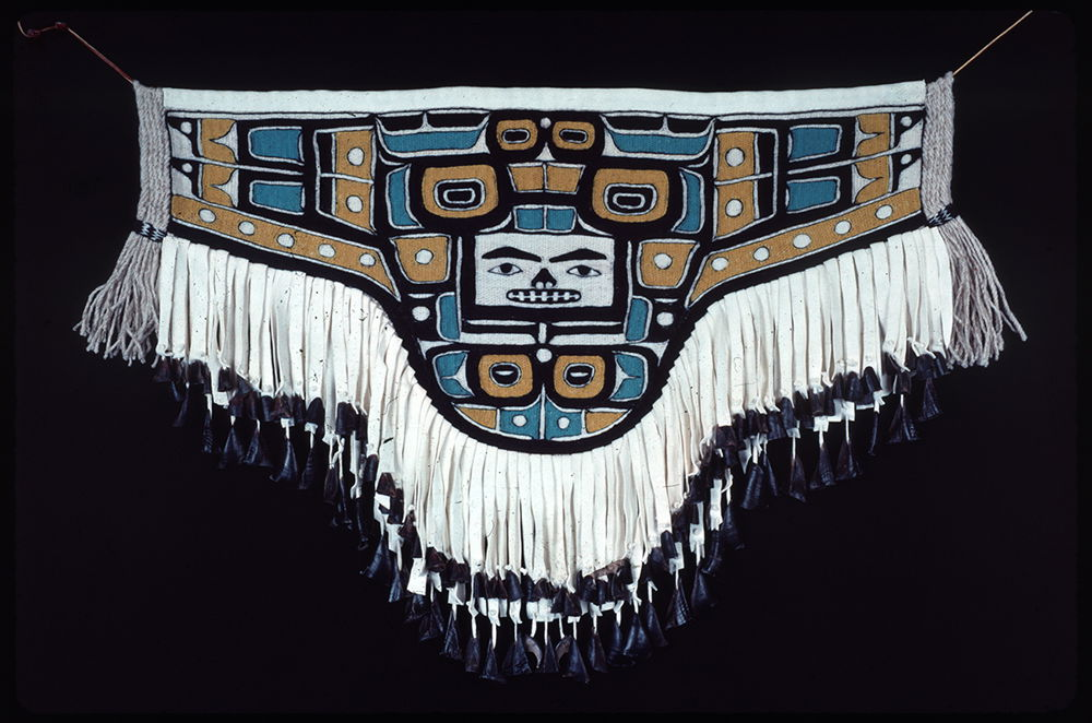 <em>Naaxiin (Chilkat) Apron</em>, 1986-1988. Australian merino wool, yellow cedar bark, deer toes. Copy of an apron with the Diving Whale design from the Field Museum.