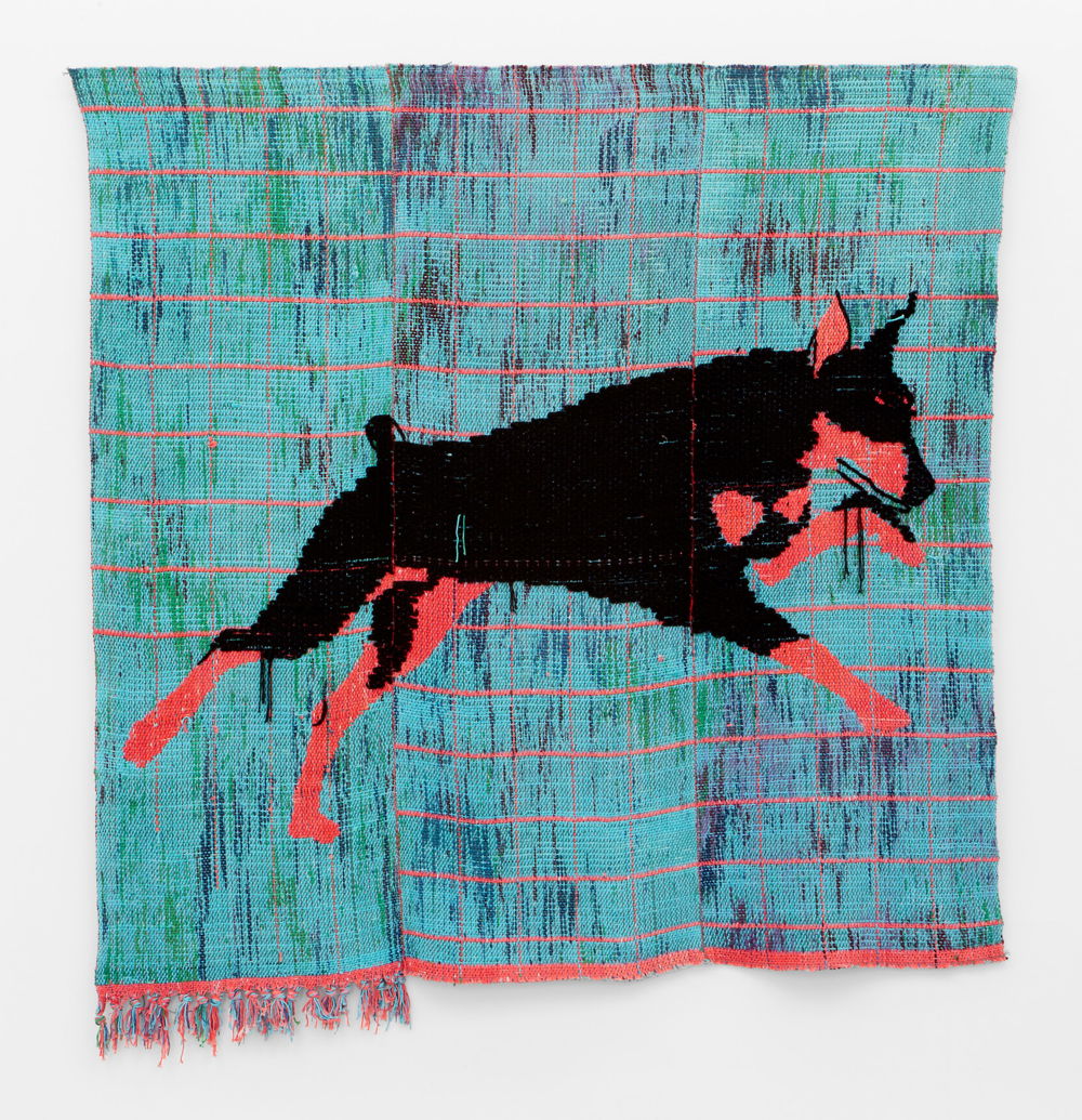 A red and black German Shepherd leaps into the air against a red-gridded background, woven with variegated Turquoise yarn subtly striped with washes of green, violet and dark blue.