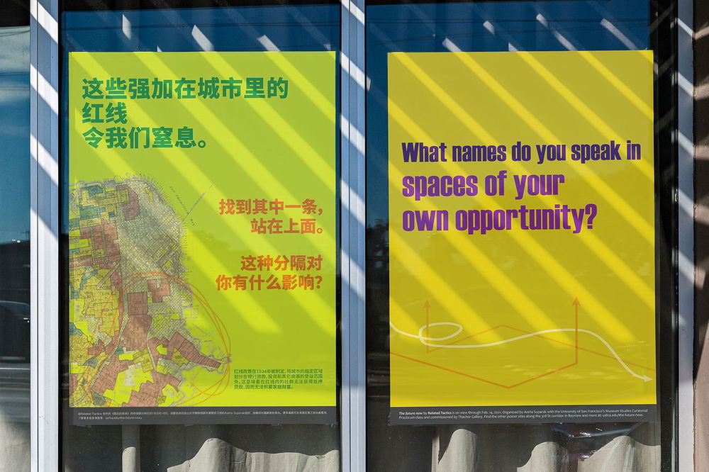 An installation of two posters in the windows of a storefront. The light yellow-green poster on the left has an image of a map and green and orange Chinese text that translates to, "The red lines drawn carefully through the city strangle us. Find one of these lines and stand one it. How have you been impacted by this division?" The yellow poster on the right reads, "What names do you speak in spaces of your own opportunity?" in purple text.