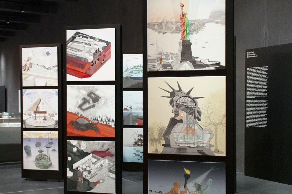Photo of installation featuring a number of structures with three stacked light boxes, which show surrealistic images of the Statue of Liberty, maps, and other diagrams.