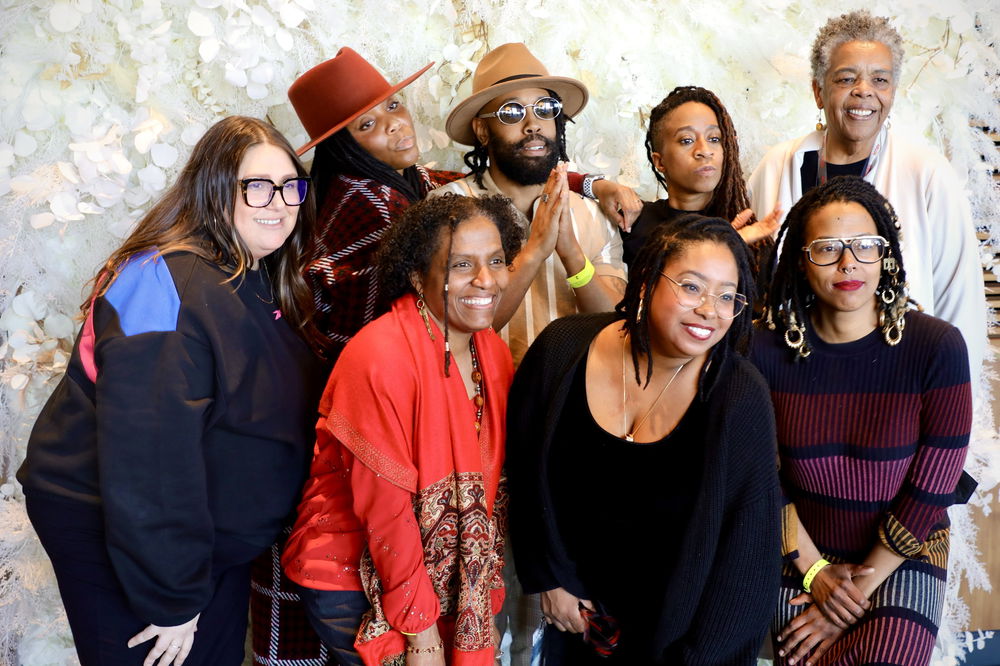 Eight people pose smiling for the camera.