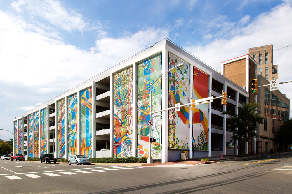 A panoramic image of colorful abstract shapes, wrapped around a sharp white downtown building.