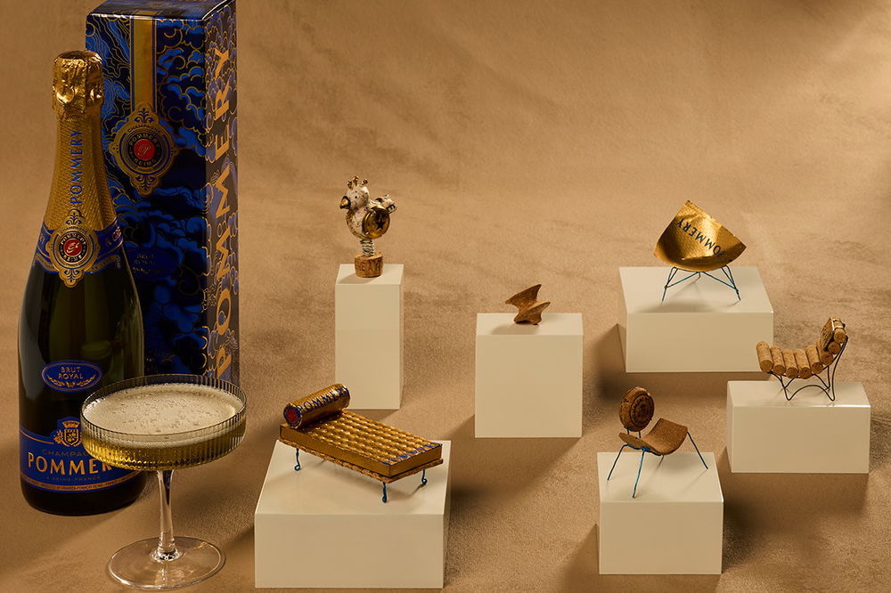 Miniature chairs constructed from champagne corks arranged on a table.