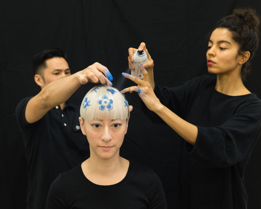 <em>How to Make a Blue and White Bowl</em> (image still), 2015. Datchuk cut her black hair and bleached it to resemble a porcelain bowl, white and decorated with cobalt blue patterns, video performance 00:36.