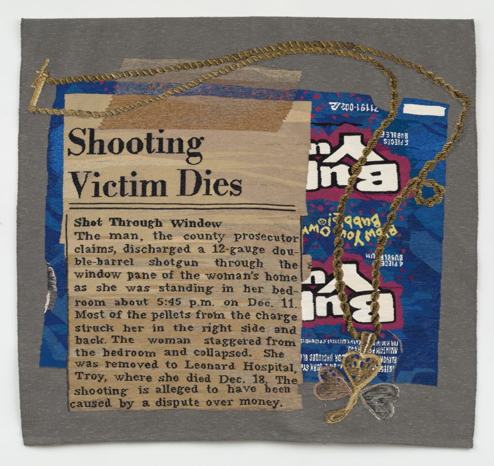 Hanging on a wall is a wool tapestry of a newspaper clipping reading "Shooting Victim Dies" and a gold rope chain necklace with a three-leaf clover in tricolor gold on top of a flattened cotton candy-flavored Bubble Yum wrapper.