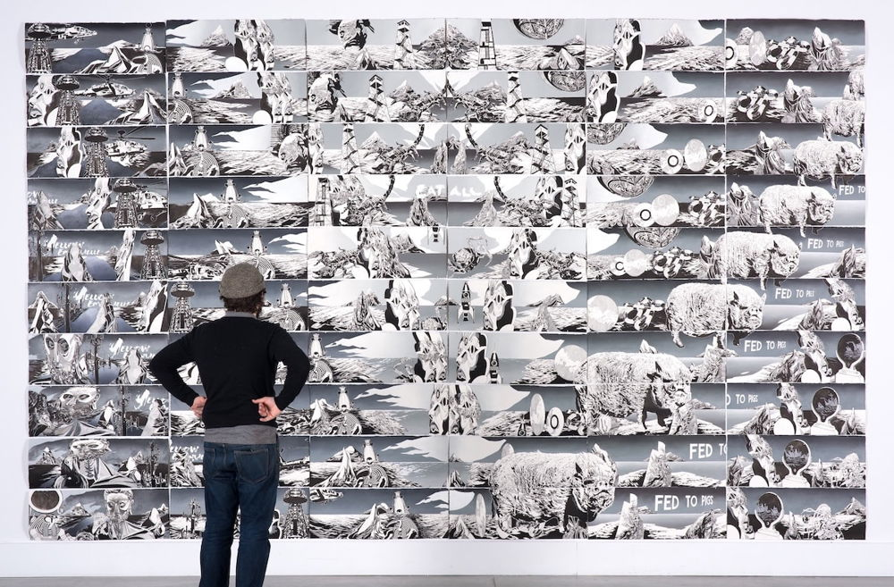 A person stands with their back to the viewer with their hands on their hips in front of a large painting. The artwork features repeating imagery, reminiscent of animation cells. Together, the images create an upside down isosceles triangle.